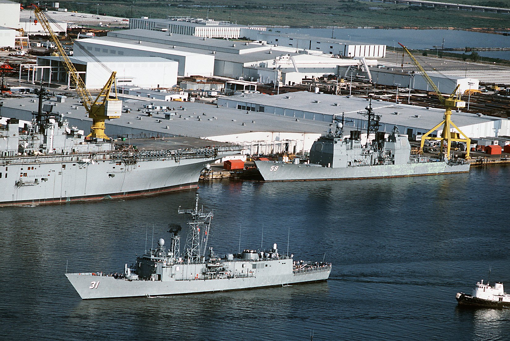 28 August 1988: Pascagoula, MS - A port bow view of the guided missile frigate USS Stark (FFG 31) en route to sea trials. The ship 
                            has just completed repairs by Ingalls Shipbuilding after suffering damage when it was struck by two iraqi-launched Exocet missiles while on patrol in the Persian Gulf. The guided missile cruiser 
                            USS Princeton (CG 59) and the amphibious assault ship USS Wasp (LHD 1) are in the background, still under construction.